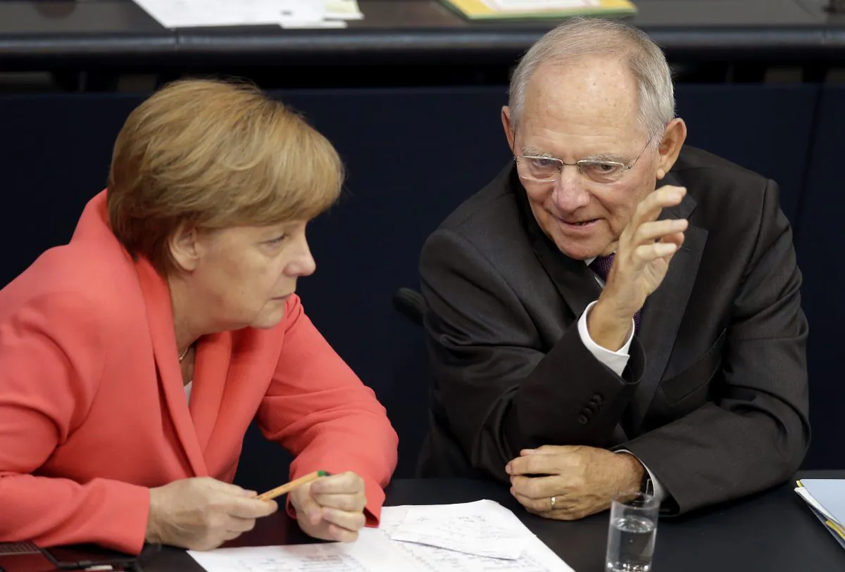 German Chancellor Angela Merkel, left, and German Finance Minister Wolfgang Schaeuble, right, talk during a meeting of the German federal parliament, Bundestag, in Berlin, Germany, Friday, July 17, 2015. (AP Photo/Michael Sohn)