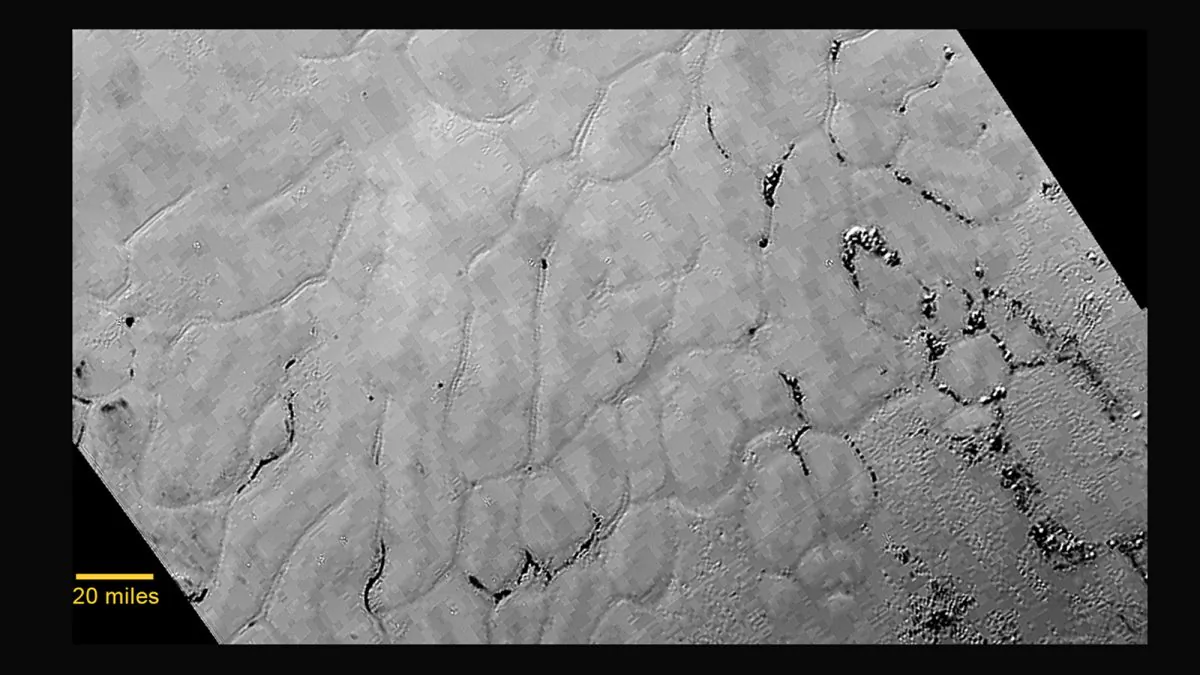 This July 14, 2015 photo provided by NASA shows an image taken from NASA's New Horizons spacecraft showing a new close-up image from the heart-shaped feature on the surface of Pluto that reveals a vast, craterless plain. (NASA/JHUAPL/SWRI via AP)