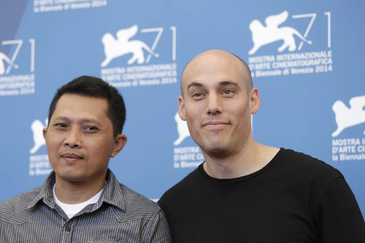Actor Adi Rukun, left, and director Joshua Oppenheimer pose for photographers at the photo call for the film The Look of Silence the 71st edition of the Venice Film Festival in Venice, Italy, Thursday, Aug. 28, 2014. (AP Photo/David Azia)