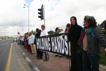 Arabs and Jews hold hands along a street. Despite differences, they have made an attempt to start a dialogue. (Tikva Mahabad/The Epoch Times)