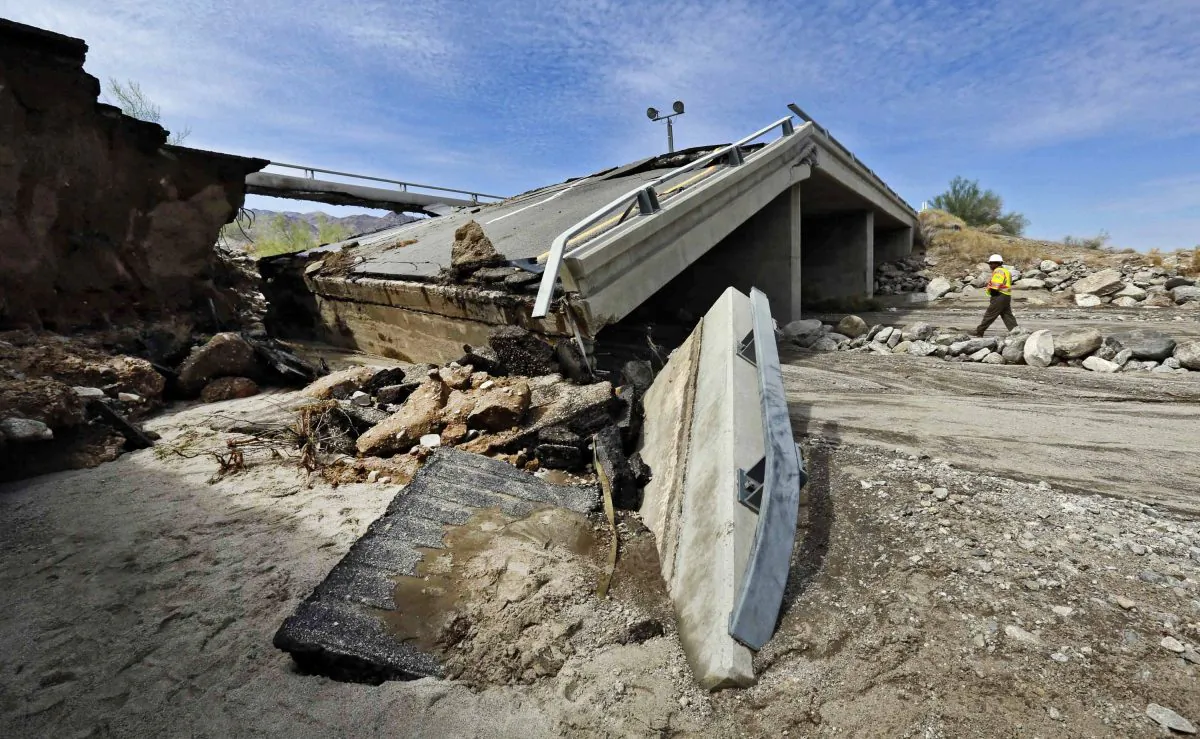 A worker walks near a washed-out bridge near the town of Desert Center, along Interstate 10 in Southern California, on Monday, July 20, 2015. (AP Photo/Nick Ut)