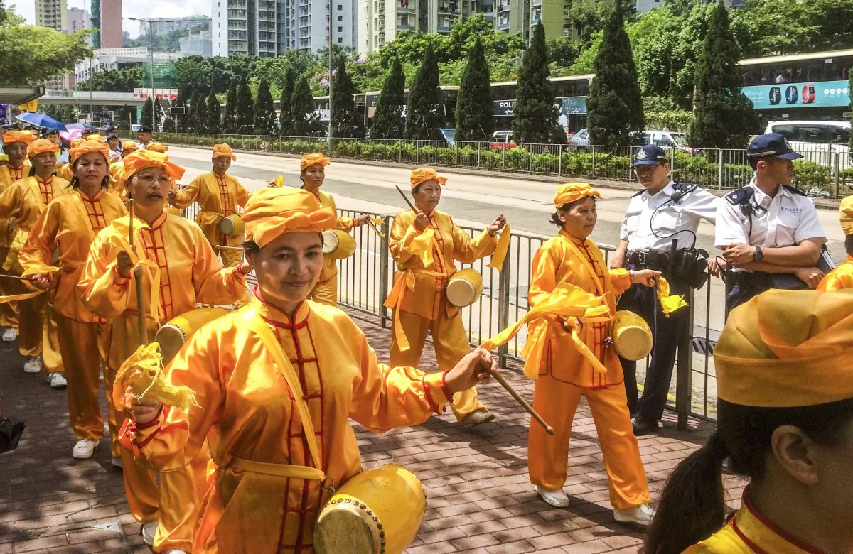The Divine Land Marching Band, a waist drum troupe,  marches through the streets of Hong Kong to mark the Chinese Communist Party's sixteen year-long persecution of Falun Gong (Phillip Evich/Epoch Times)