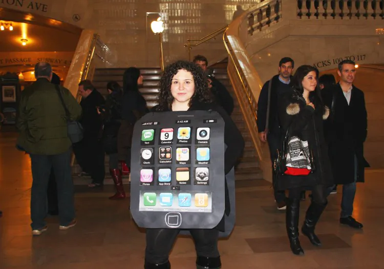 A petitioner dressed as an Apple iPhone protests outside the Apple Store in Grand Central Terminal in New York on Feb. 9. Petitioners cry fowl about the labor practices in the Chinese factories that make Apple products. (Hannah Cai/The Epoch Times)