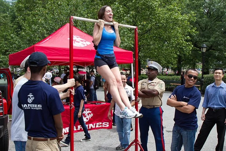 A woman does pull-ups near a recruitment tent at Marine Day at Battery Park May 25.(Benjamin Chasteen/The Epoch Times)