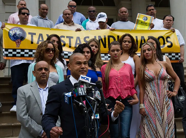 Fernando Mateo (Front), president of the New York State Federation of Taxi Drivers, gathered on City Hall steps on Thursday with about a dozen taxi drivers and about a dozen women. (Zachary Stieber/The Epoch Times)