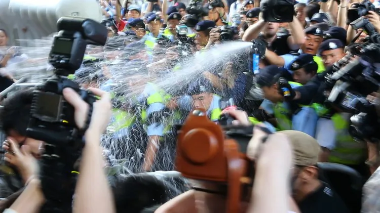 A protester rinses his eyes with water after being hit with pepper spray by Hong Kong police. (Liang Lusi/The Epoch Times)