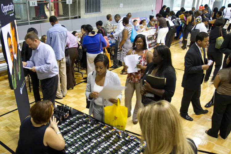 People wait in line at the Starbucks career booth at a job fair in East Harlem on Aug. 15, in New York City. (Benjamin Chasteen/The Epoch Times)