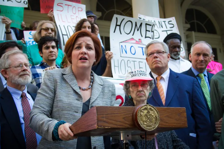 Ann Cunningham, tenant of an apartment illegally used as a hotel, joins a rally on the steps of City Hall Wednesday. (Benjamin Chasteen/The Epoch Times)