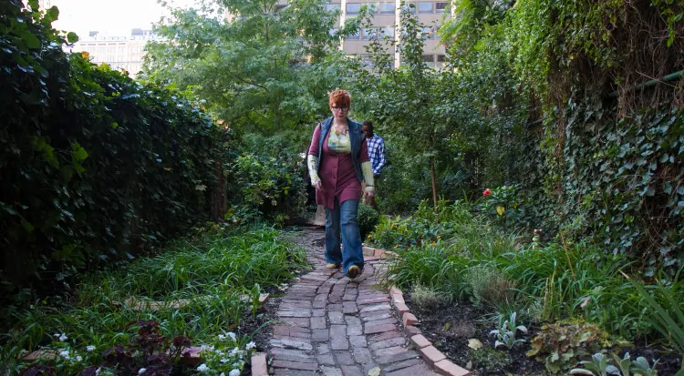 Lauren Kennedy, an intern for Alice’s Garden in New York, walks down the brick path that was donated by the Hudson Yards Redevelopment Project. (Benjamin Chasteen/The Epoch Times)