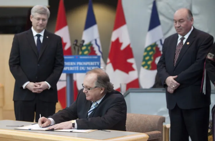 Prime Minister Stephen Harper and Bob McLeod, premier of the Northwest Territories, look on as Bernard Valcourt, minister of aboriginal affairs and northern development, signs a devolution agreement between the federal government and NWT. Harper travelled to Yellowknife to sign the deal Monday, which will make the territory responsible for granting oil and gas rights as well as managing the land within its boundaries. It will also enable NWT to collect some royalties on resource development. Although a second round of consultations still needs to take place with aboriginal groups and other stakeholders, it is expected that the handover will occur on April 1, 2014. (Deb Ransom)