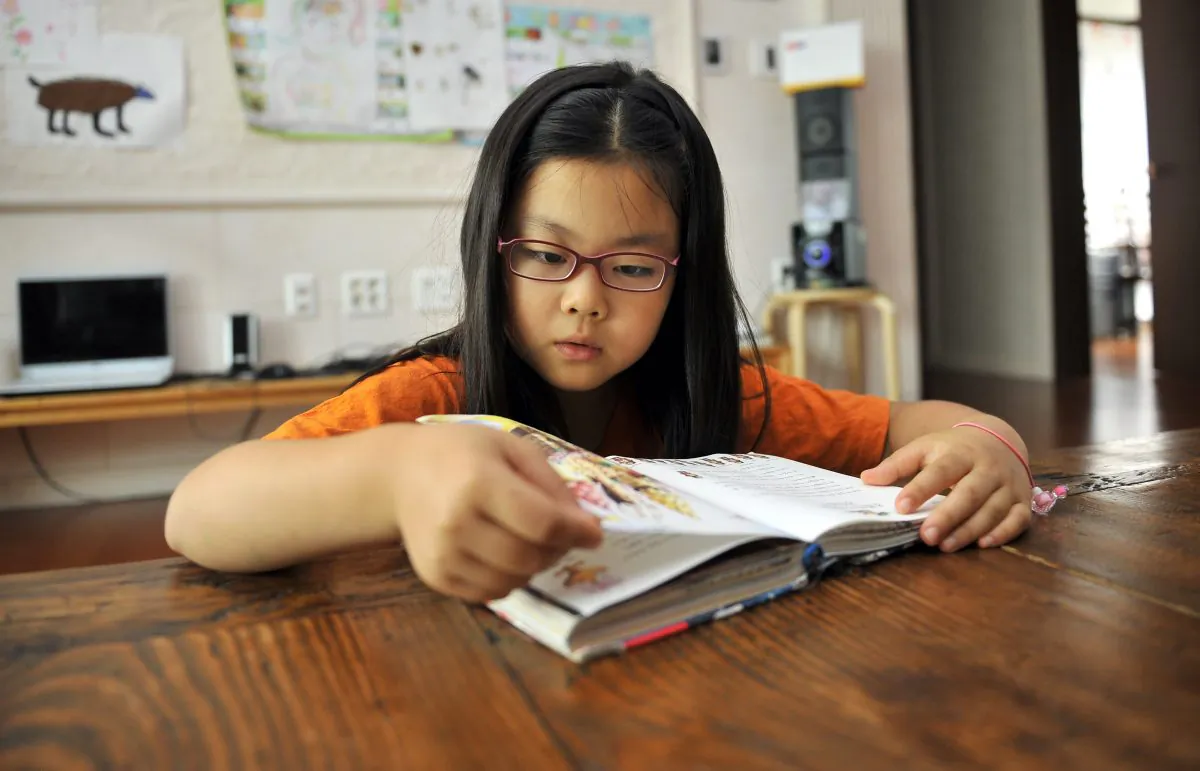 9-year-old student reads a book at home. (Jung Yeon-Je/AFP/Getty Images)