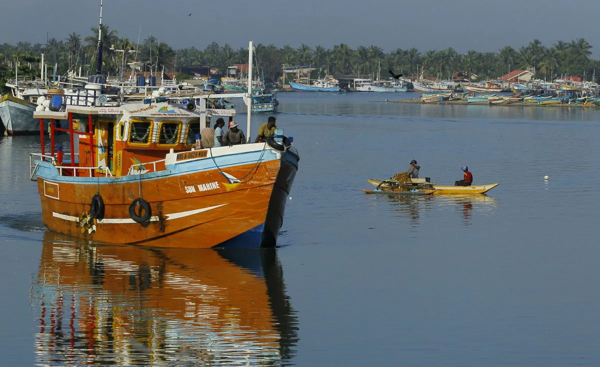 Sri Lankan fishermen stand on a fishing vessel as it leaves a fishery harbor in Negombo, Negombo, outskirts of Colombo, Sri Lanka, on Oct.15, 2014. (AP Photo/Eranga Jayawardena)