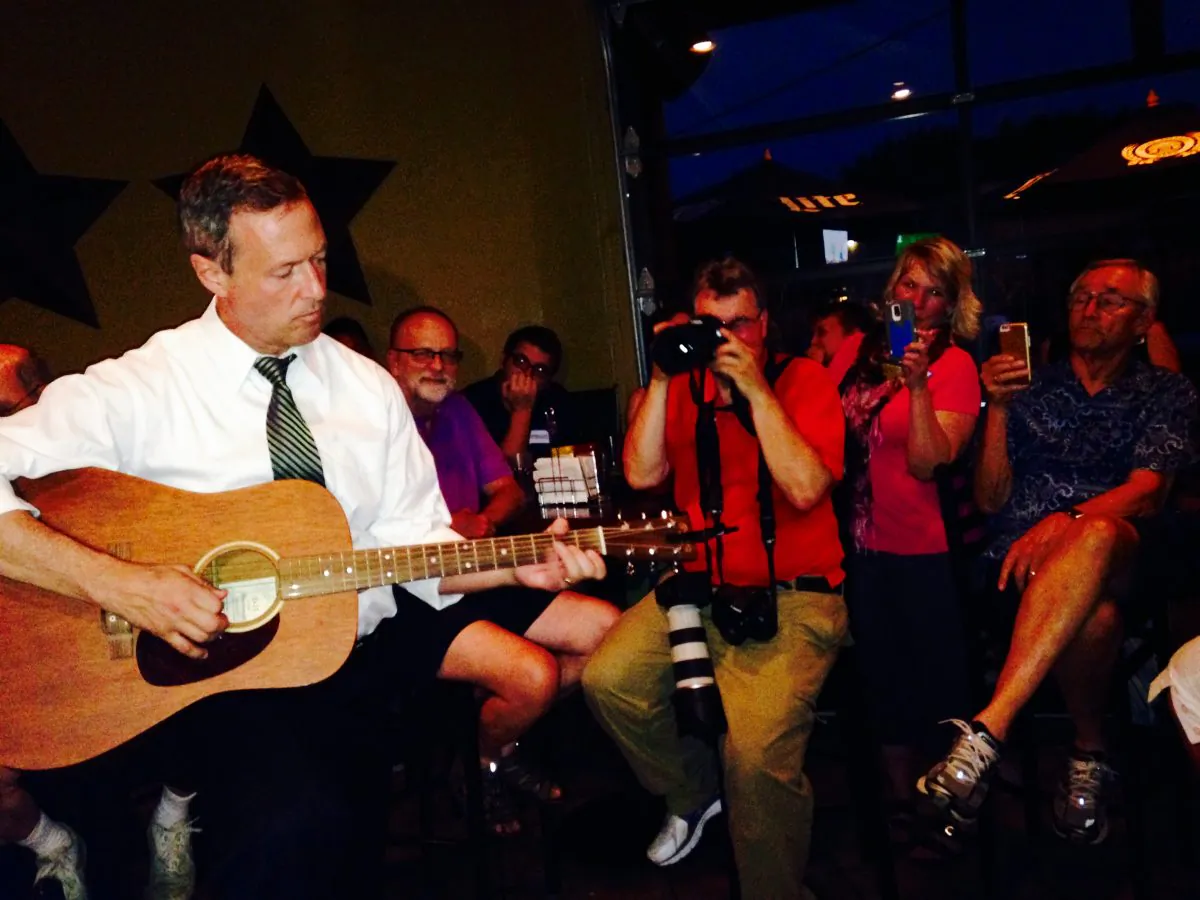 Democratic presidential hopeful Martin O'Malley plays guitar at a bar Friday, July 24, 2015, in the Beaverdale section of Des Moines, Iowa. (AP Photo/Catherine Lucey)