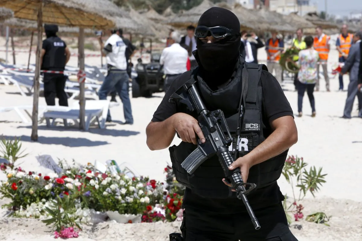 In this Monday, June 29, 2015 file photo, a hooded Tunisian police officer stands guard ahead of the visit of top security officials of Britain, France, Germany and Belgium at the scene of Friday's shooting attack in front of the Imperial Marhaba hotel in the Mediterranean resort of Sousse, Tunisa. (AP Photo/Abdeljalil Bounhar)