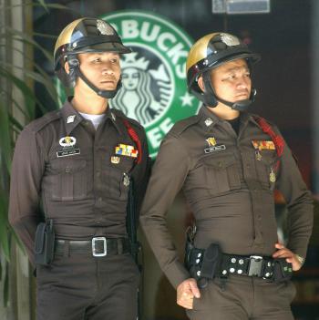 Thai police outside one of the over 30 Starbuck coffeehouses in Bangkok. (Adek Berry/Getty Images)