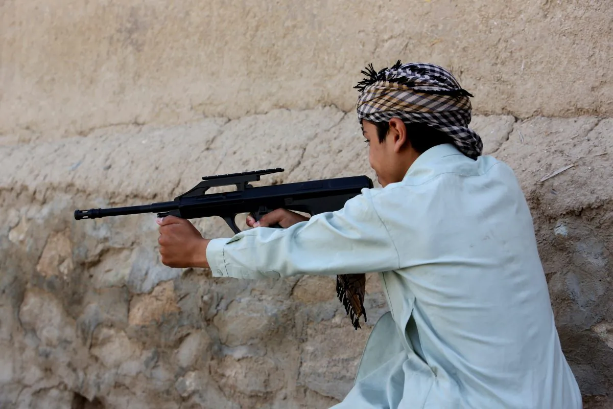 In this Saturday, July 25, 2015 photo, an Afghan boy plays with his friends using a toy gun, in Kabul, Afghanistan. At least 184 people, nearly all children, suffered eye injuries over the recent Eid al-Fitr holiday from toy weapons that fire BB pellets and rubber shot, health officials said. In response, authorities have called on police to destroy all the toy guns officers comes across. (AP Photo/Rahmat Gul)