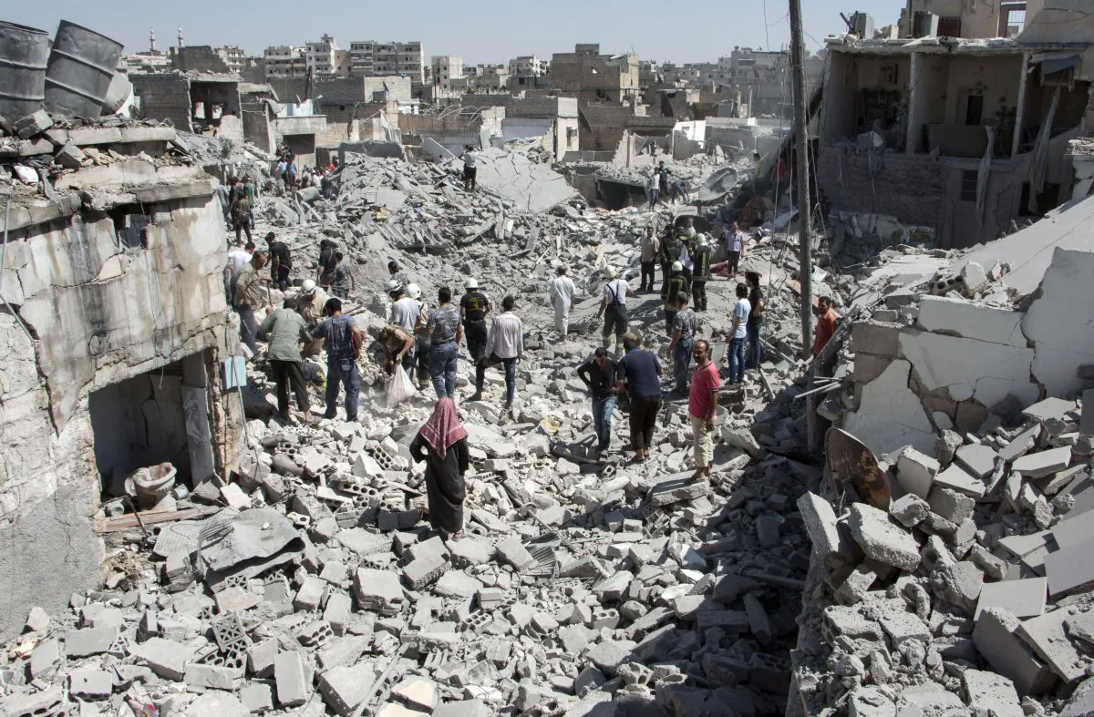 Syrians stand on the rubble of buildings after a missile fired by Syrian government forces hit a residential area in the Maghayir district in the old quarter of the northern Syrian city of Aleppo on July 21, 2015.   (KARAM AL-MASRI/AFP/Getty Images)