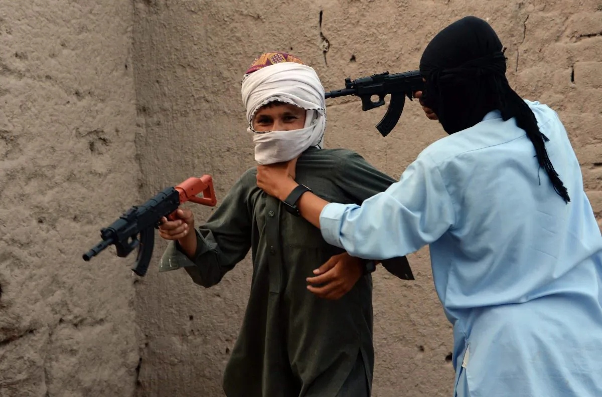 In this photograph taken on July 18, 2015, Afghan children play with plastic guns as they celebrate the second day of Eid al-Fitr which marks the end of the holy fasting month of Ramadan, on the outskirts of Jalalabad city in eastern Nangarhar province. Afghanistan banned the sale of imitation Kalashnikovs and other toy guns July 21 after they caused injuries to more than 100 people during Eid celebrations, seeking to curb a culture of violence among children. AFP PHOTO/ Noorullah Shirzada (Photo credit should read Noorullah Shirzada/AFP/Getty Images)