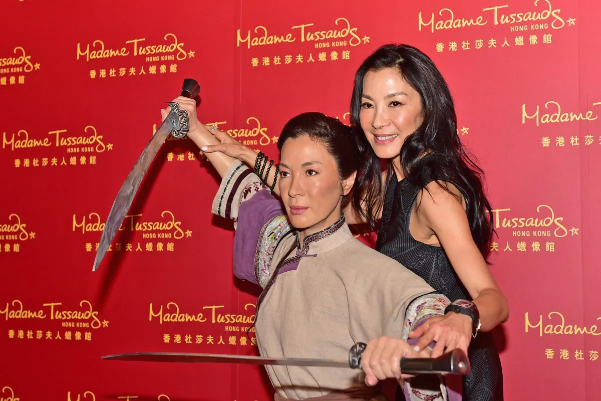 Actress Michelle Yeoh poses with her Madam Tussauds, Kung Fu wax figure at its unveiling to the public in Hong Kong on July 27, 2015. (Bill Cox/Epoch Times)