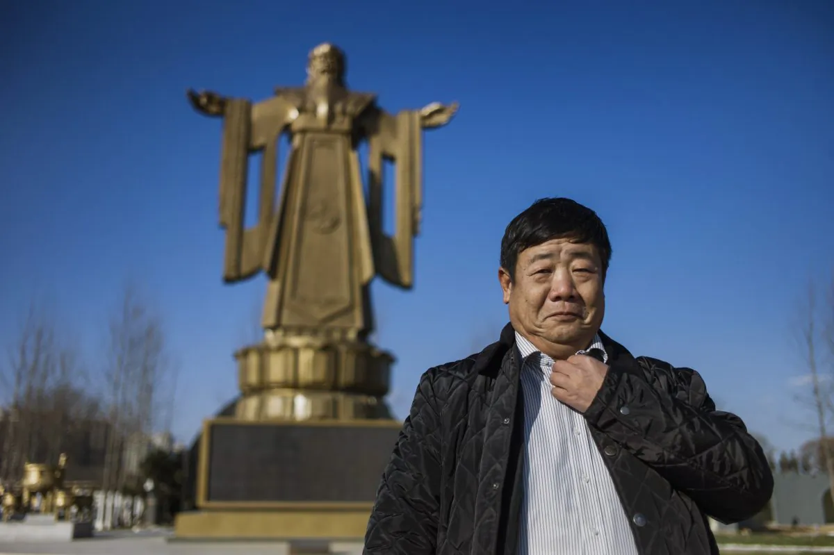 Former Chinese general Wang Dianming posing next to a Confucius statue in the seaside resort in Beidaihe, Hebei province. (FRED DUFOUR/AFP/Getty Images)