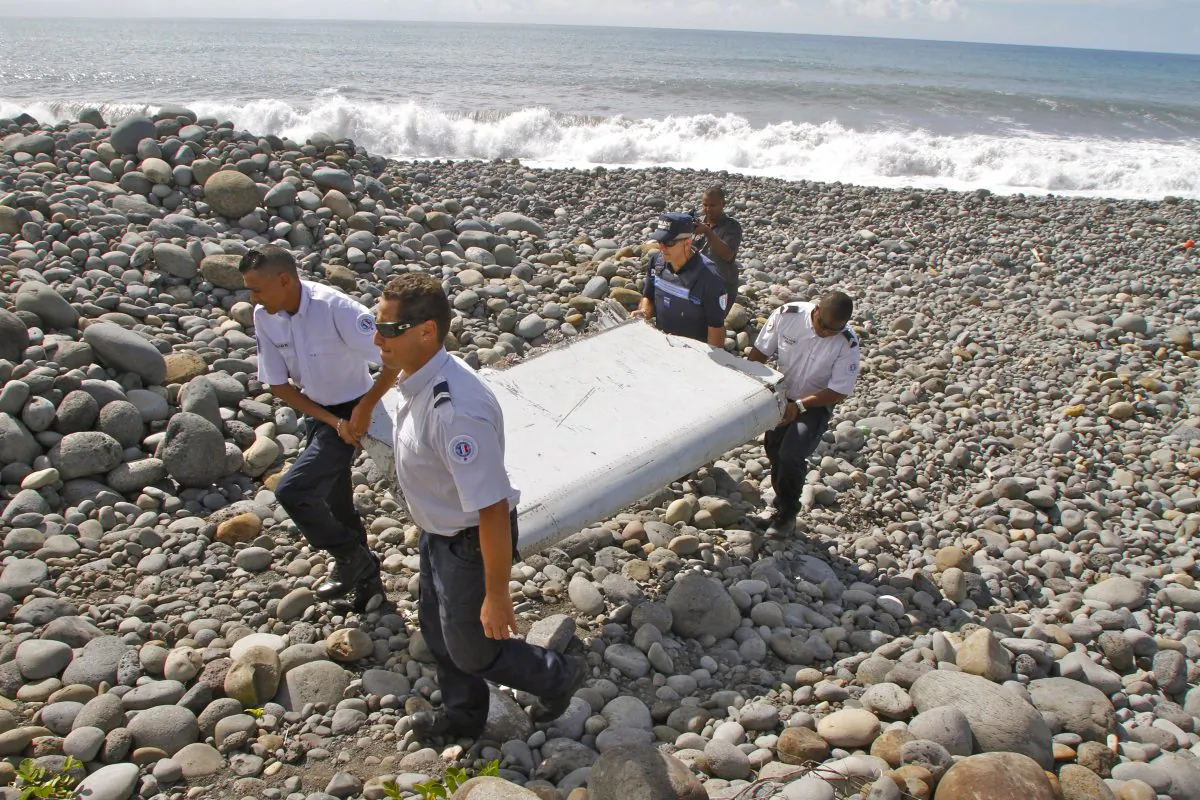 French police officers carry a piece of debris from a plane in Saint-Andre, Reunion Island on Wednesday, July 29, 2015. (AP Photo/Lucas Marie)