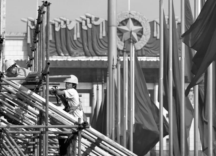 A man rides a tricycle over the rails next to a cargo train in Beijing on Aug. 7, 2009. The head of Liaoning Province volunteered China's economic data were made up; he relied on volume of freight moved by train as one indicator of actual economic performance. (Liu Jin/AFP/Getty Images)