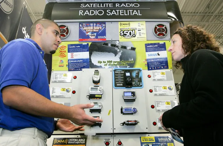 An electronics store employee helps a customer shop for a satellite radio. (Justin Sullivan/Getty Images)