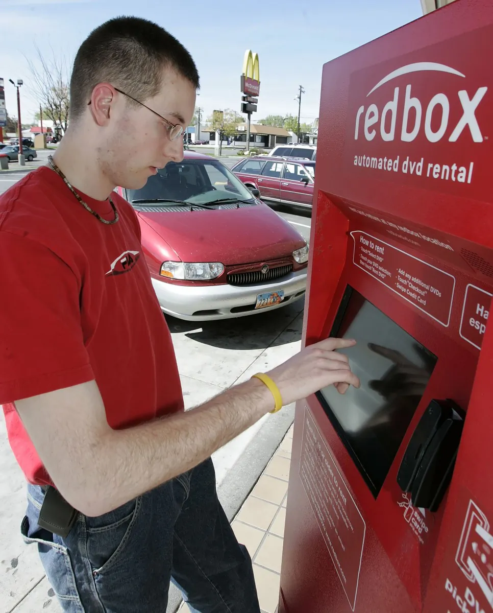 In this file photo, a customer orders DVDs from a Redbox kiosk in Prevo, Utah. Redbox and Verizon are teaming up to create a new video-subscription service. (George Frey/Getty Images)