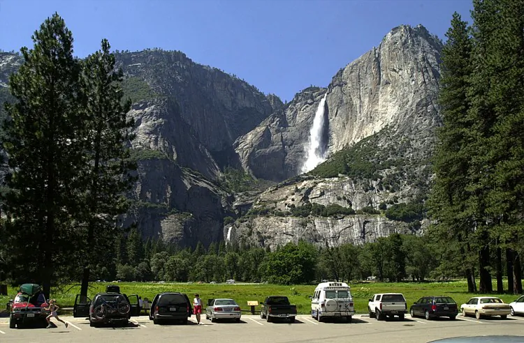 Cars fill a parking lot near Yosemite Falls (background) in Yosemite National Park, Calif. Members of the military will now be eligible for a pass providing free access to national parks and recreational sites across the United States. (David McNew/Newsmakers)
