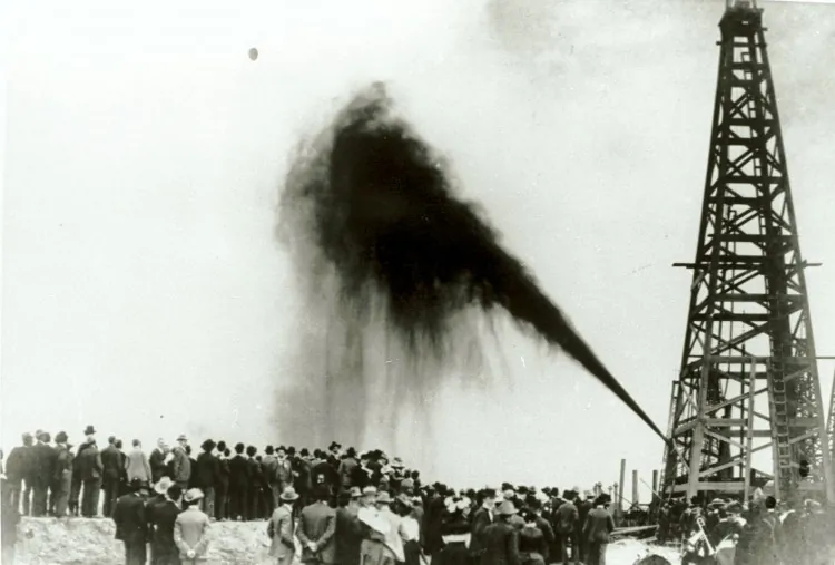 A crowd gathers to watch a side gusher on Spindletop Hill in Beaumont, Texas in 1901. Communities are concerned about the danger of oil wells in close proximity to schools and homes, but in a land built on oil, sometimes the wells were there first. (Texas Energy Museum/Newsmakers)