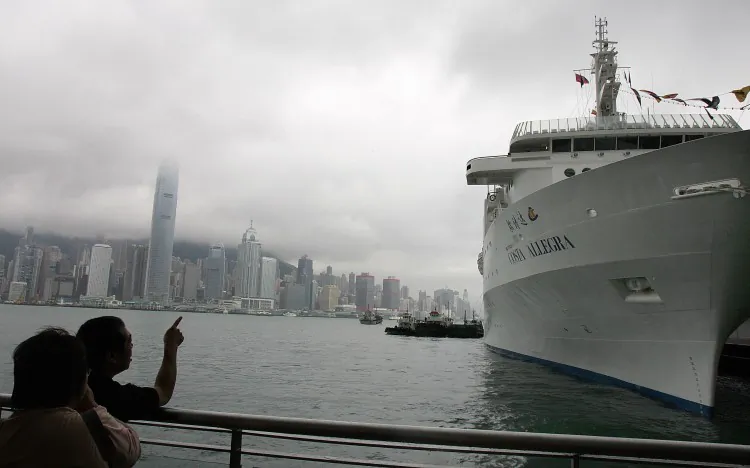 Local residents look at the Costa Allegra cruise liner berthed in Hong Kong prior to its maiden voyage to Mumbai, India in May 2006. (Laurent Fievet/AFP/Getty Images)