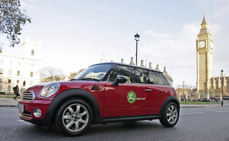 A Zipcar-owned Mini Cooper is seen driving past the Palace of Westminster in London, England. On Jan. 2, Zipcar was acquired in a $500 million deal by car rental giant Avis Budget. (Scott Barbour/Getty Images)