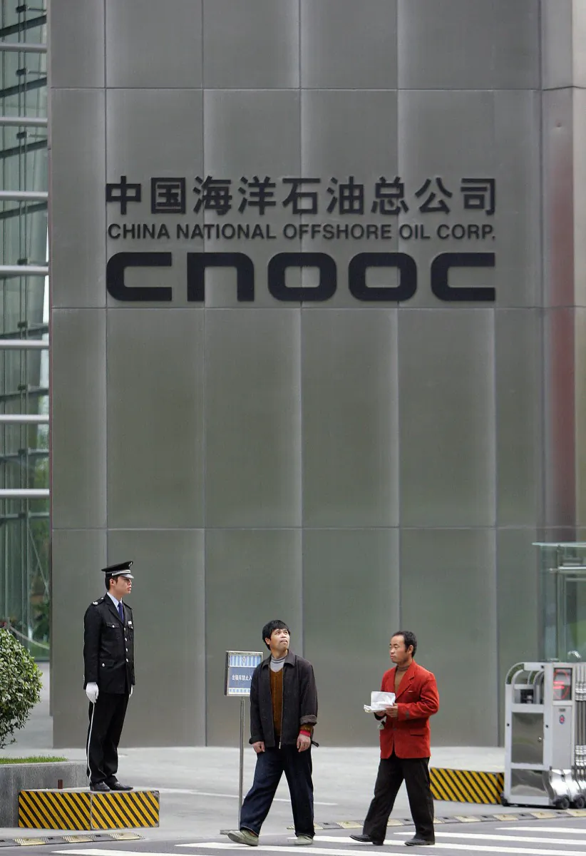 In a file photo from 2007, a security guard mans his post in front of CNOOC global headquarters in Beijing. CNOOC last week reached an agreement to purchase Canada-based Nexen for $15.1 billion. (Frederic J. Brown/AFP/Getty Images)