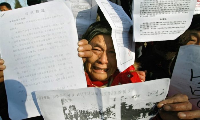 Petitioners hold up documents describing their grievances in Beijing, 2007. The Communist Party has recently moved to sweep up these individuals, along with known rights activists, in a move to suppress dissent before the 18th National Party Congress scheduled for November. (Teh Eng Koon/AFP/Getty Images)