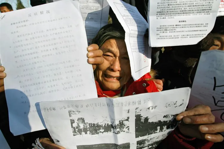Petitioners hold up documents describing their grievances in Beijing, 2007. The Communist Party has recently moved to sweep up these individuals, along with known rights activists, in a move to suppress dissent before the 18th National Party Congress scheduled for November. (Teh Eng Koon/AFP/Getty Images)