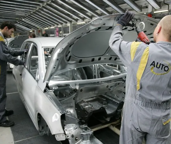 Employees work on a Volkswagen (VW) car at the company’s plant in the northwestern German city of Wolfsburg. The German automaker is looking to improve work-life balance for its employees. NIGEL TREBLIN/AFP/Getty Images