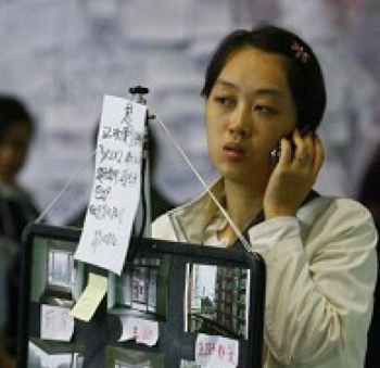 A lady promoting her apartment in the Autumn Real Estate Show in southwest China's Chongqing city on October 24. (GETTY IMAGES) A lady promoting her apartment in the Autumn Real Estate Show in southwest China's Chongqing city on October 24. (GETTY IMAGES)