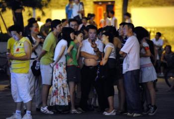 Chinese residents gather around to watch the Beijing Olympics in Beijing. (Goh Chai Hin/AFP/Getty Images)