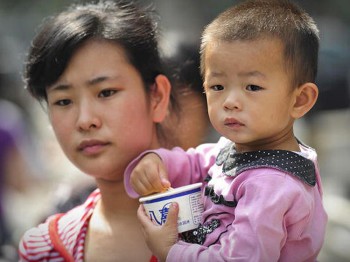 A mother leaves a children's hospital with her child in Beijing on September 22, 2008 as China's toxic milk scandal escalated after officials admitted nearly 53,000 children had been sickened by contaminated products and more countries moved to ban or lim (Peter Parks/AFP/Getty Images)