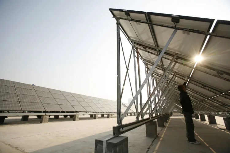 A worker cleans solar panels at a solar photovoltaic power station, under construction in November 2008 in Xining, Qinghai Province, China. (China Photos/Getty Images)