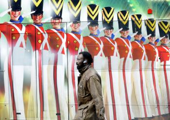 A man walks by a painted advertisement on a side of a bus for Broadway production of the Radio City Christmas Spectacular show, in New York. (Emmanuel Dunand/AFP/Getty Images)