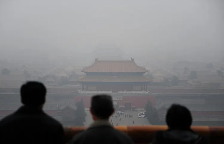 Tourists take in the view of the Forbidden City from atop Coal Hill in Jingshan Park, north of the former imperial palace on a smoggy day in Beijing on Dec. 10, 2009. (Frederic J. Brown/AFP/Getty Images)