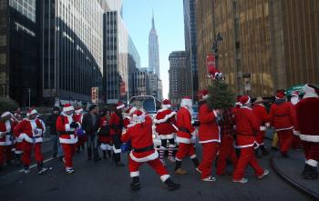 SantaCon: New Yorkers, dressed as Santa Claus, walk past the Empire State Building during the annual Santacon event, Dec. 12, 2009 in New York City. (Mario Tama/Getty Images)