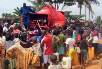 People wait as buckets and jerry cans are filled with water from a truck at a distribution point in Yaounde on February 21, 2010. (STR/AFP/Getty Images)