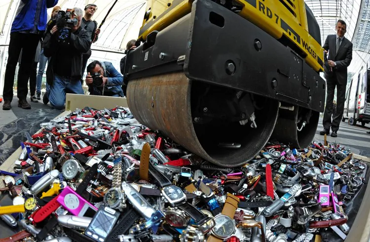 Customs officers use a roller to destroy counterfeit MP3 players and watches at the airport in Munich, Germany on April 22, 2010. (Joerg Koch/AFP/Getty Images)