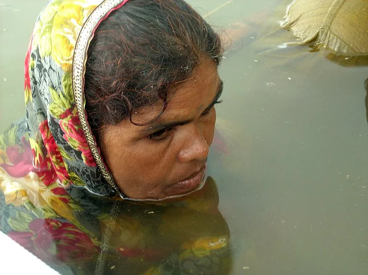 Protesters sitting in the water during a 17-daylong protest receive food from volunteers. (Courtesy of Narmada Bachao Andolan)