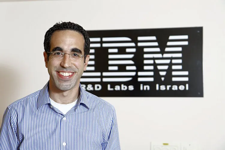 Shaharabani, a senior expert for data security at IBM, stands for a photo near the company logo at his office in Israel. (Epoch Times Staff)