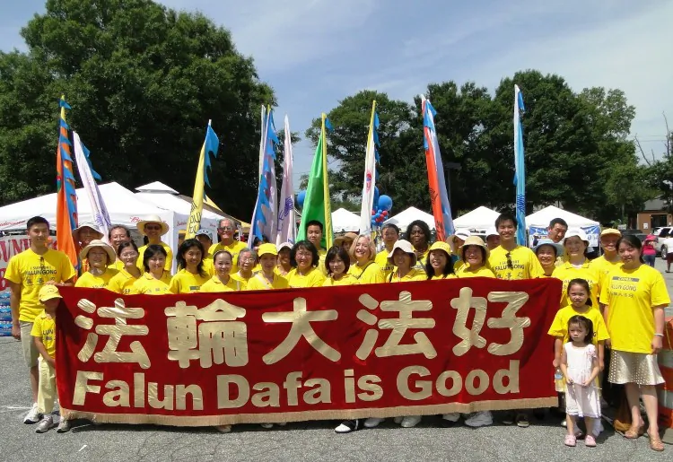 Falun Gong practitioners march in the Dunwoody, Ga. parade for the first time with (L-R) Xiaoyi Li, Joseph Beckenbach and Fan Hongyan leading the way. (Frank Xie/Epoch Times Staff)