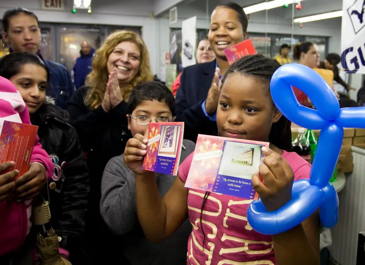 Children at The Salvation Army's Briarwood Family Residence discuss their "Pictures of Hope" holiday card creations on Wednesday in Brooklyn. This girl's photos say, "My dream is to have a safe home," and "My dream is to have a beautiful life." (Amal Chen/The Epoch Times)