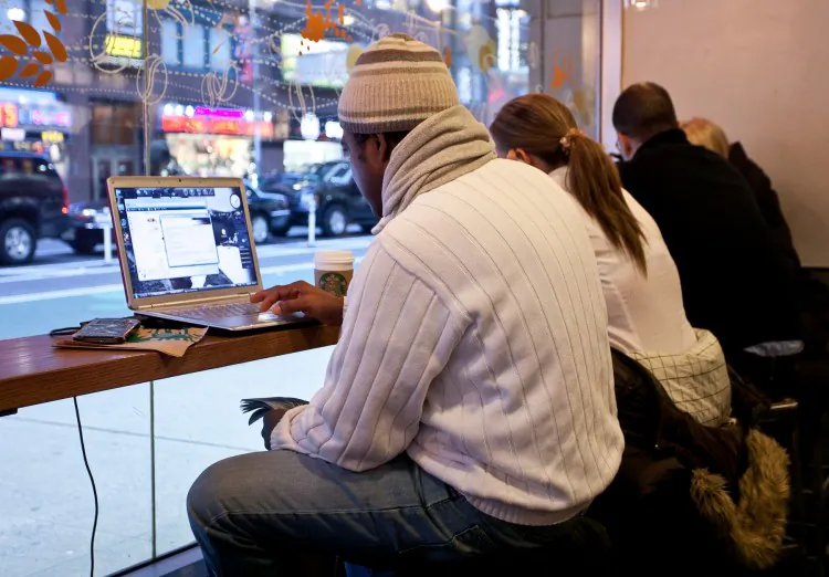 People use their laptops at a coffee shop in New York City in this file photo. A new "Connect NY" program will provide funding to expand broadband Internet access in New York. (Amal Chen/The Epoch Times) 